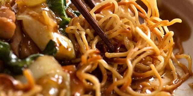 Close up photo of chopsticks picking up Chinese Crispy Noodles (Chow Mein)