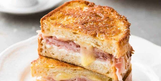 Monte Cristo Sandwich cut in half and stacked on each other on a small white plate, ready to be eaten.
