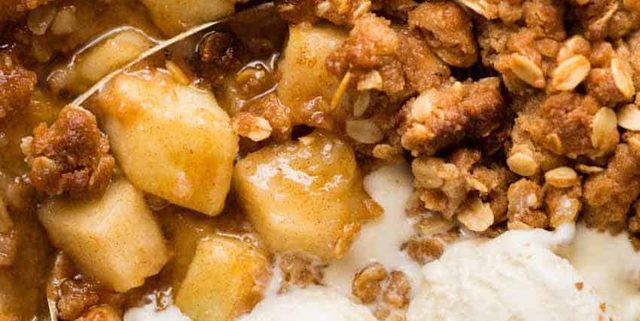 Close up overhead photo of Apple Crumble with scoops of vanilla ice cream