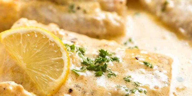 Close up photo of Baked Fish with Lemon Cream Sauce in a white pan, fresh out of the oven