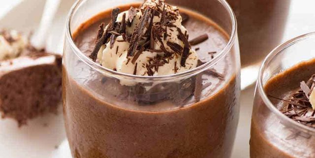 Chocolate Mousse in glasses topped with a dollop of cream and chocolate shavings, ready to be served