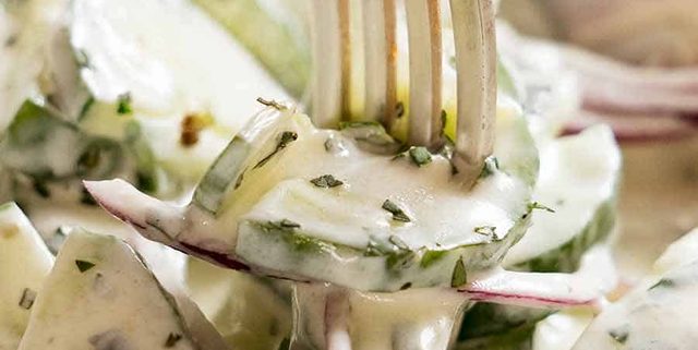 Close up of fork picking up Cucumber Salad with Lemon Mint Yogurt Dressing