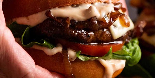 Hand holding juicy Swiss Mushroom Burgers