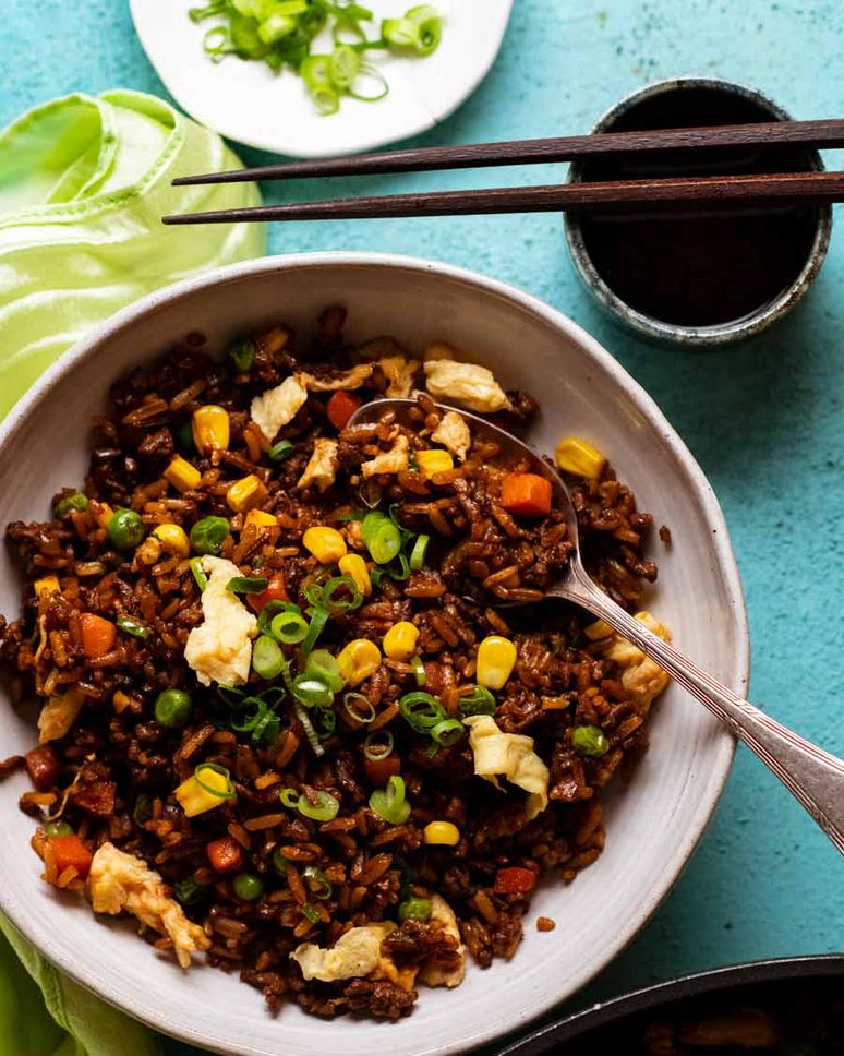 Beef fried rice served in a bowl with tender strips of beef, egg, and vegetables