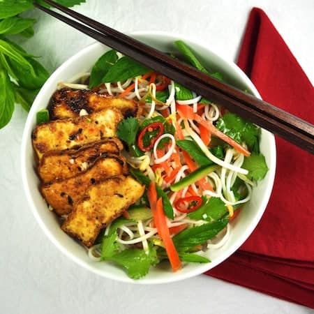 Vegetarian Vietnamese Noodle Bowl (vegan) with Marinated Tofu in a white bowl with chopsticks, ready to be eaten.
