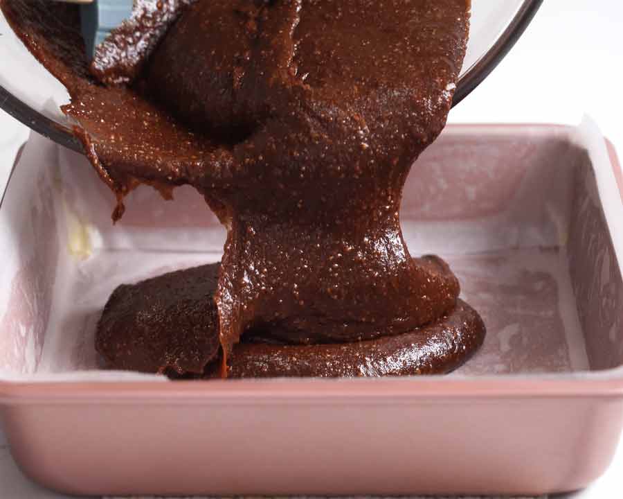 Gluten free flourless chocolate brownies batter being poured into baking pan