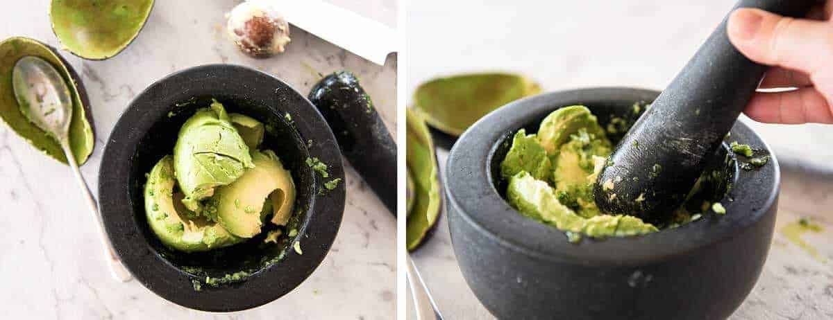 Avocado in a mortar and pestle being mashed for guacamole.