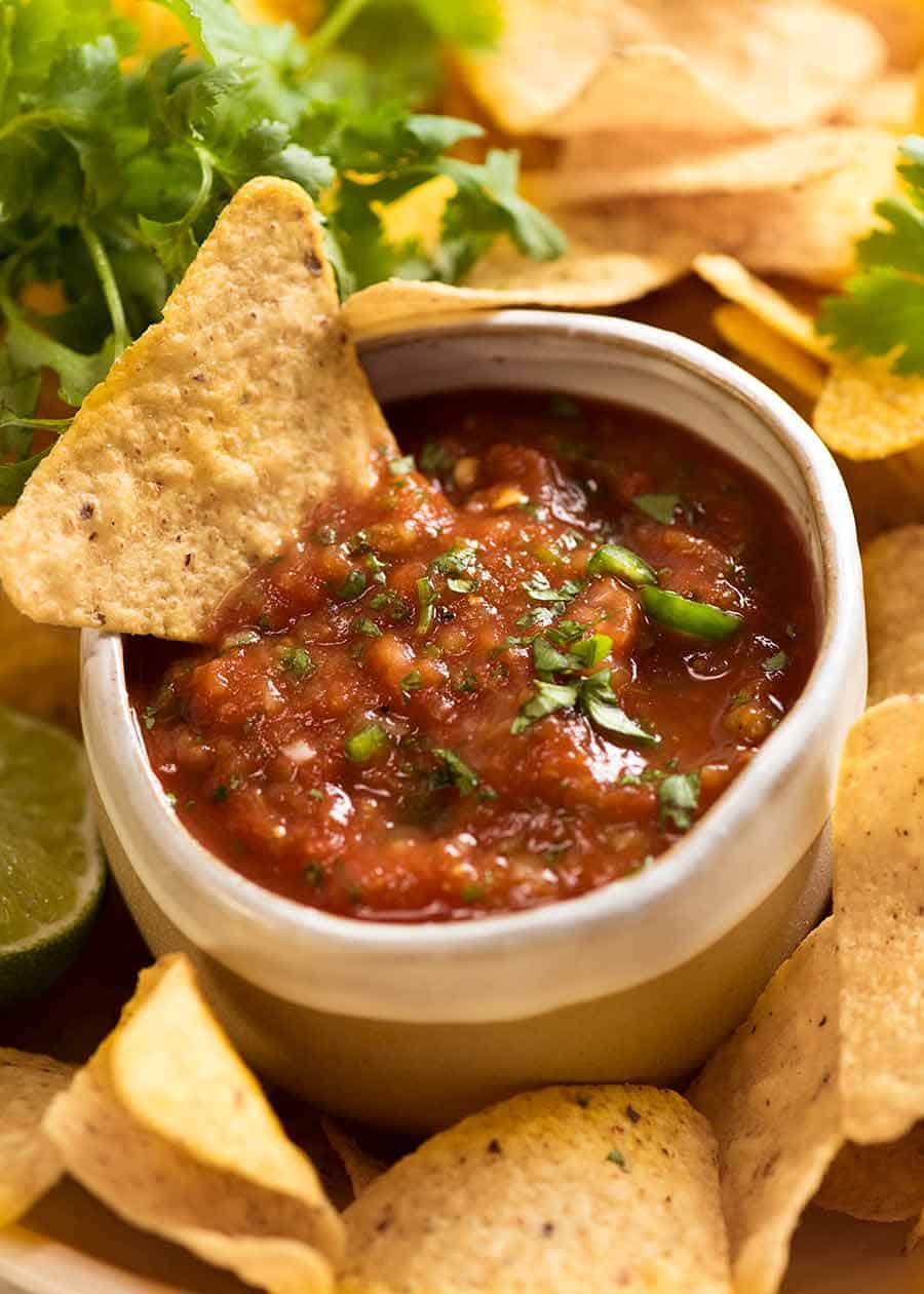 Salsa recipe for restaurant style salsa. Salsa in a ceramic bowl with corn chips.