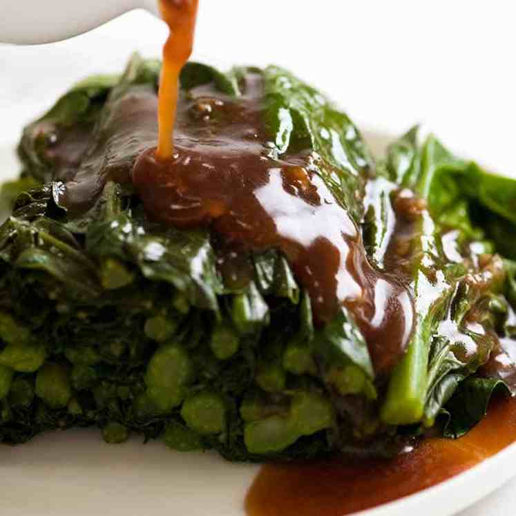 Pouring Garlic Ginger Oyster Sauce over steamed Chinese Broccoli