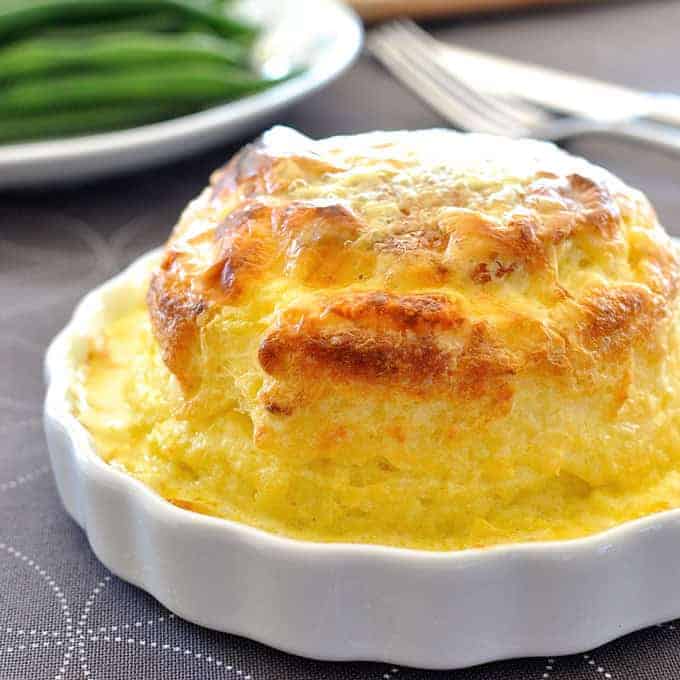 Souffle you can make ahead - freezer and refrigerator friendly. Cheesy, light as air soufflé covered in a luscious creamy sauce.