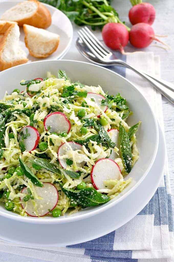 Pea, Cabbage, Parmesan and Mint Salad in a white bowl