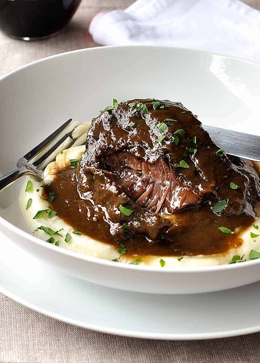 Slow cooked beef cheeks in red wine sauce on creamy mashed potato