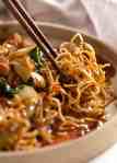 Close up photo of chopsticks picking up Chinese Crispy Noodles (Chow Mein)