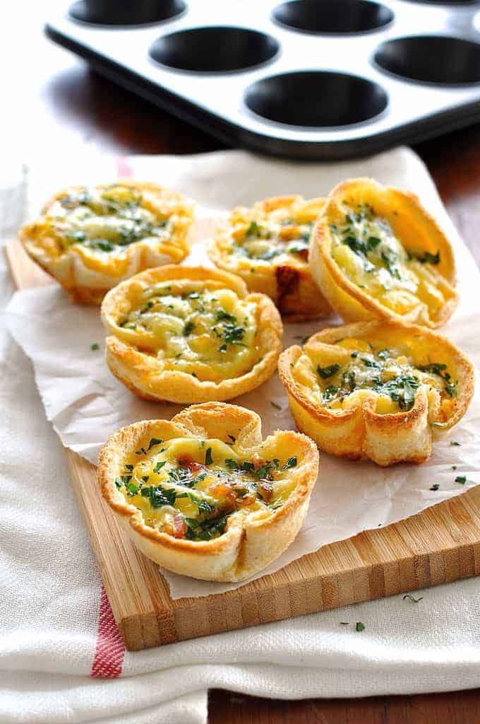 A pile of Quiche Toast Cups (toast bread cups filled with quiche filling)