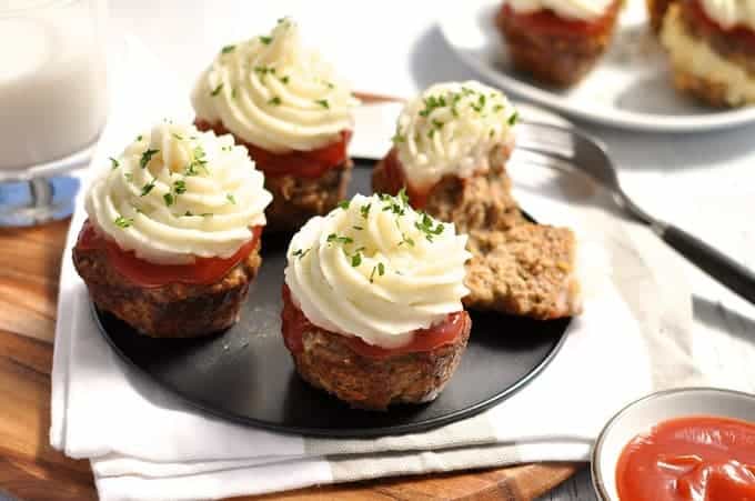 Meatloaf Cupcakes with Mashed Potato topping on a grey tray, ready to be served with tomato ketchup on the side.