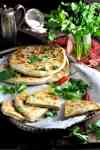 Aloo Paratha (Indian Potato Stuffed Flatbreads) filled with mashed potato and spiced beef on a tray, ready to be served.