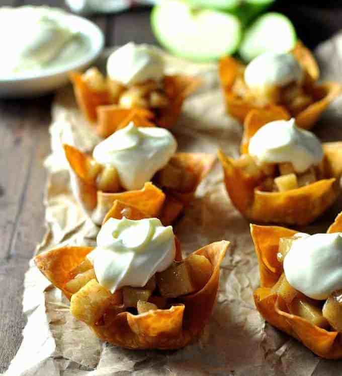Mini Apple Pies made with wonton cups with a dollop of cream, ready for serving.