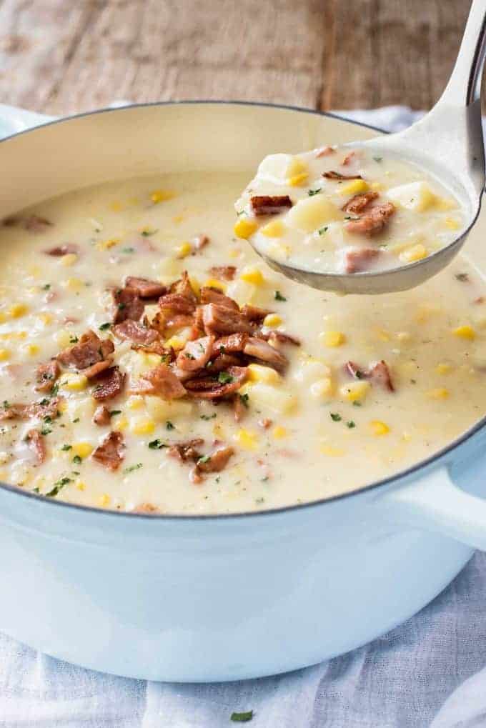 Ham and Corn Chowder in a French casserole pot being ladled out for serving.