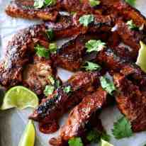 A tray of Oven Baked Ribs with Chipotle Barbecue Sauce scattered with cilantro