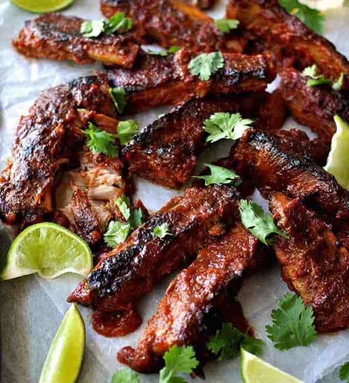 A tray of Oven Baked Ribs with Chipotle Barbecue Sauce scattered with cilantro