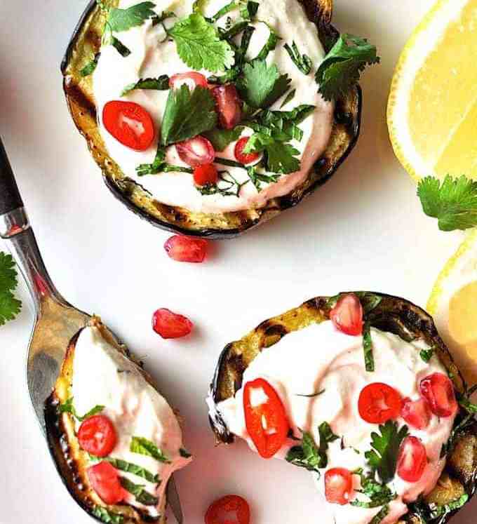 Grilled Eggplant discs topped with yoghurt sauce, pomegranate and coriander