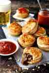 A stack of Party Pies on baking paper with tomato sauce (ketchup)