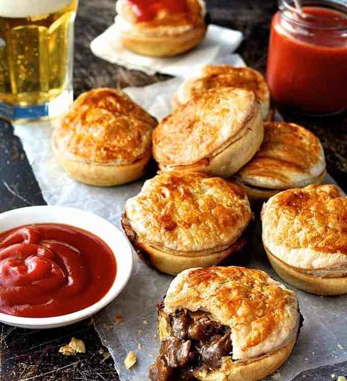 A stack of Party Pies on baking paper with tomato sauce (ketchup)