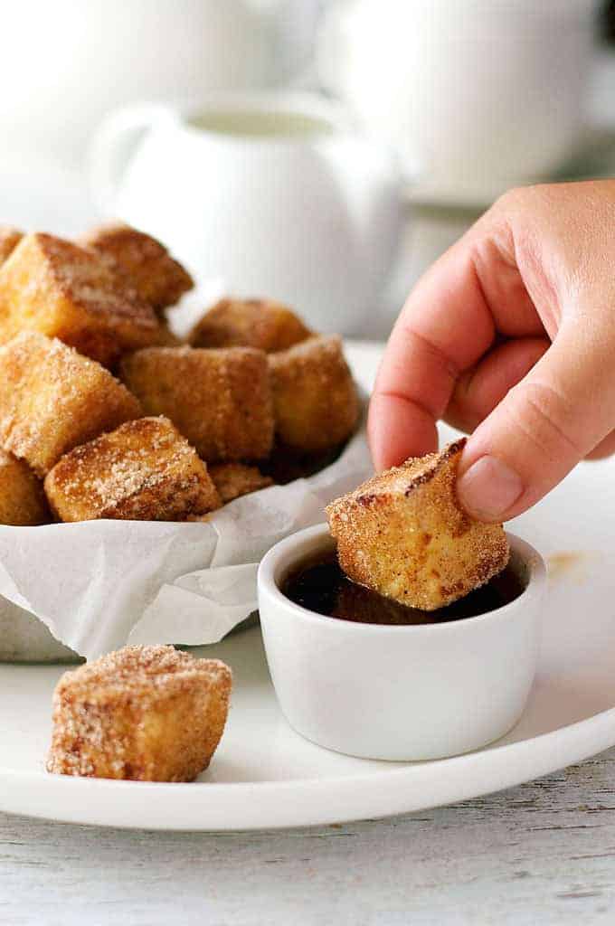 Dipping Cinnamon French Toast Bites into maple syrupe