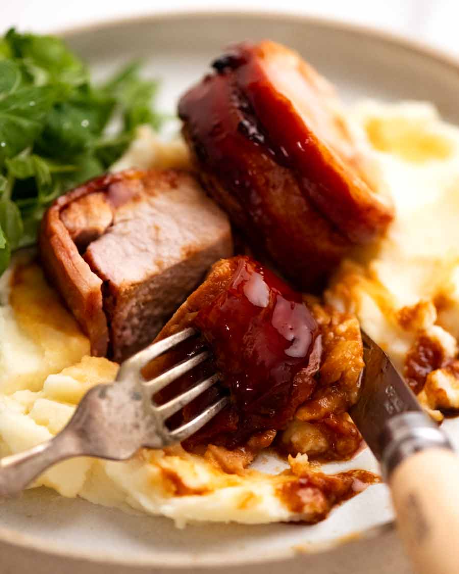 Slices of Bacon wrapped pork tenderloin on mashed potato