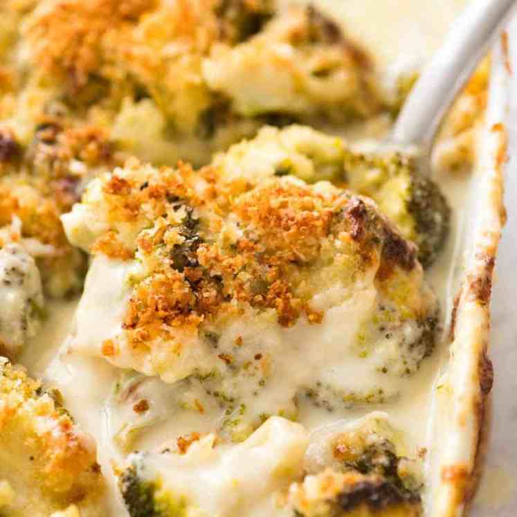 Close up of a spoon scooping up a serving of creamy garlic parmesan Broccoli Casserole