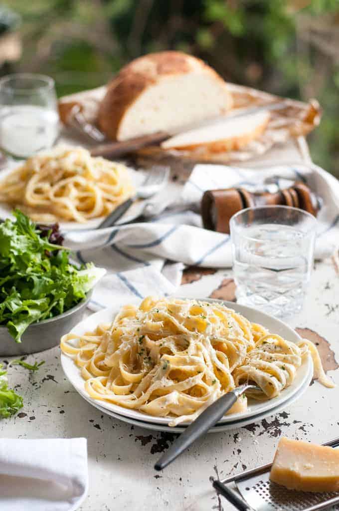 Table with Fettuccine Alfredo, salad and bread