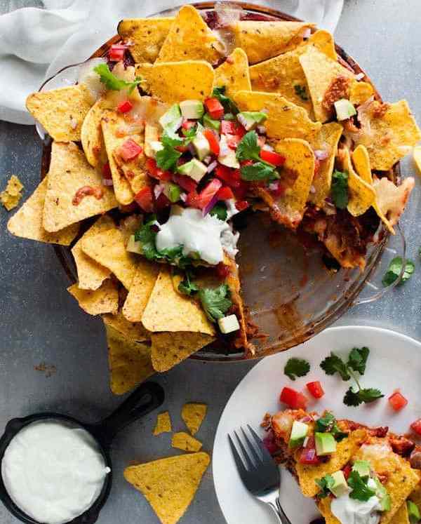 Nachos Pie topped with salsa, served with extra sour cream