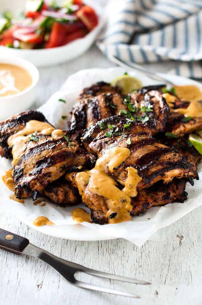 Grilled Coconut Marinated Chicken on a plate, drizzled with coconut sauce.