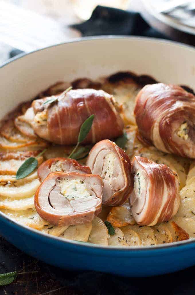 Prosciutto Wrapped Chicken and Scalloped Potatoes in a round blue casserole pan