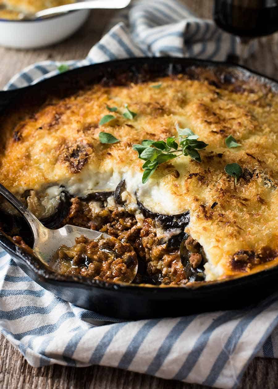 Moussaka in a black skillet, fresh out of the oven, ready to be served
