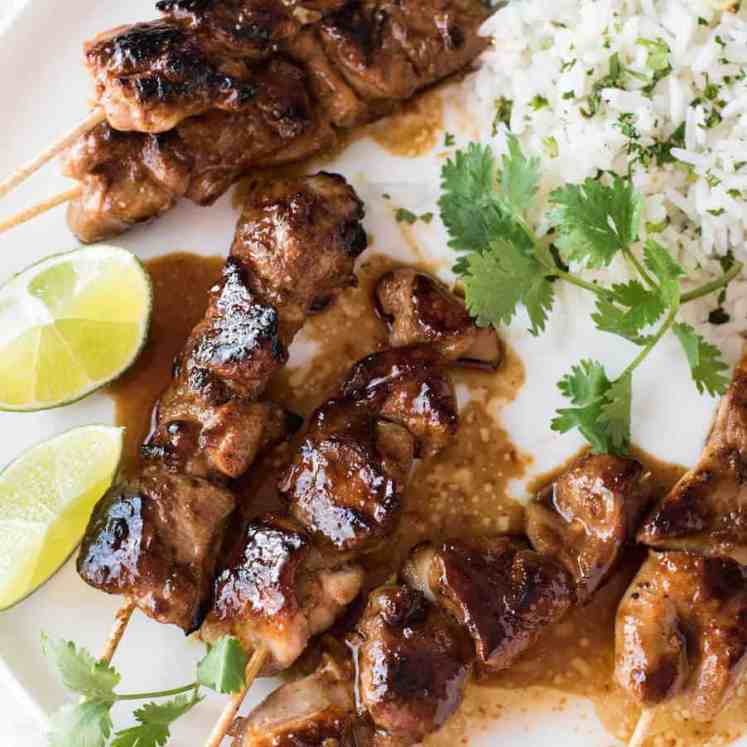 Honey Sriracha Chicken Skewers on a white plate with a side of coconut lime cilantro rice.