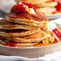 Pouring syrup over Ricotta pancakes