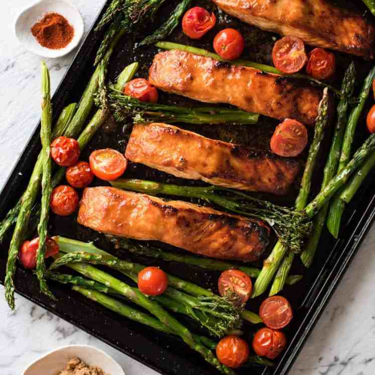 Spicy Brown Sugar Salmon on tray with asparagus and tomatoes