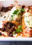 Close up of beef enchiladas in a baking dish, fresh out of the oven