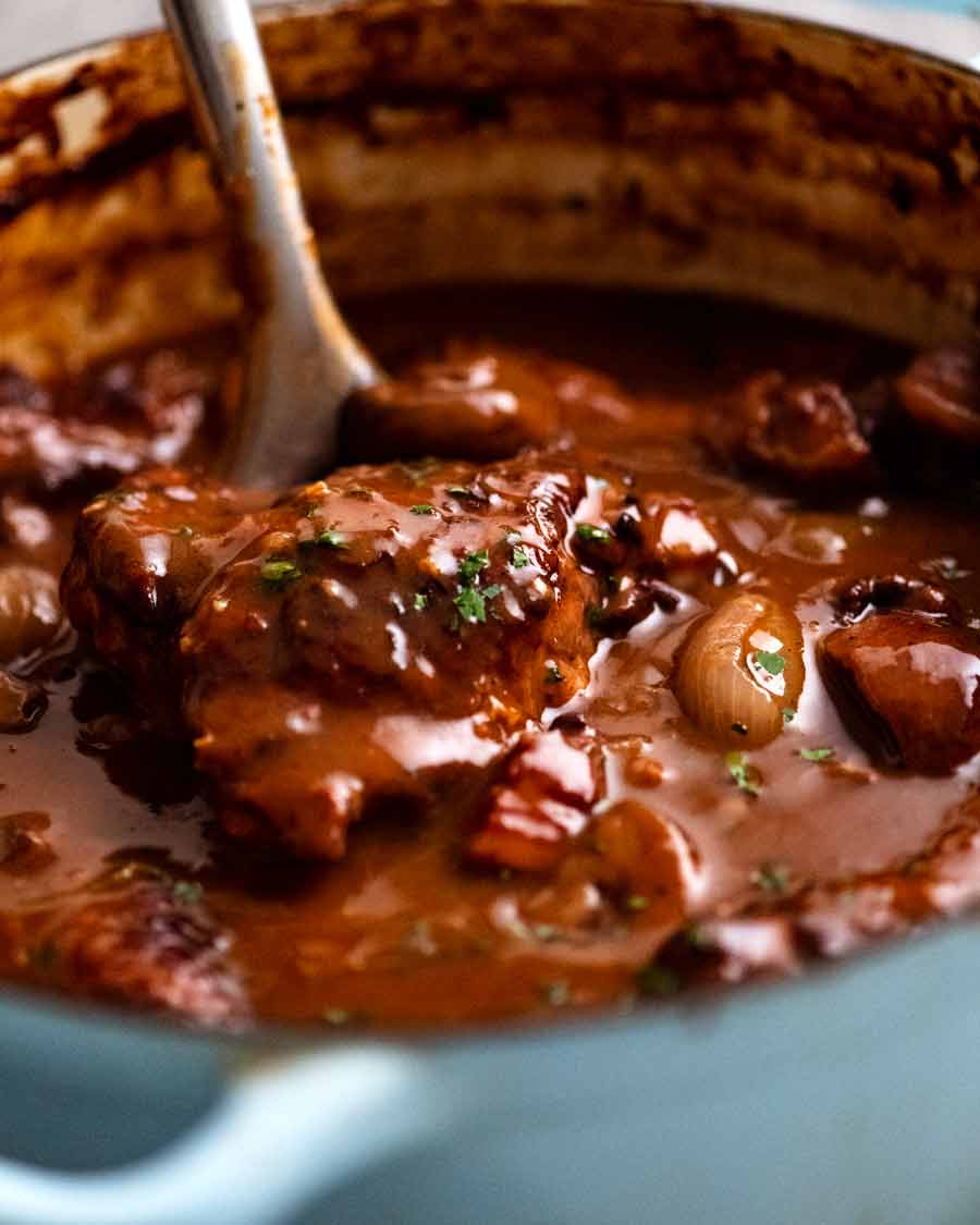 Serving freshly cooked Coq au Vin - French chicken stew