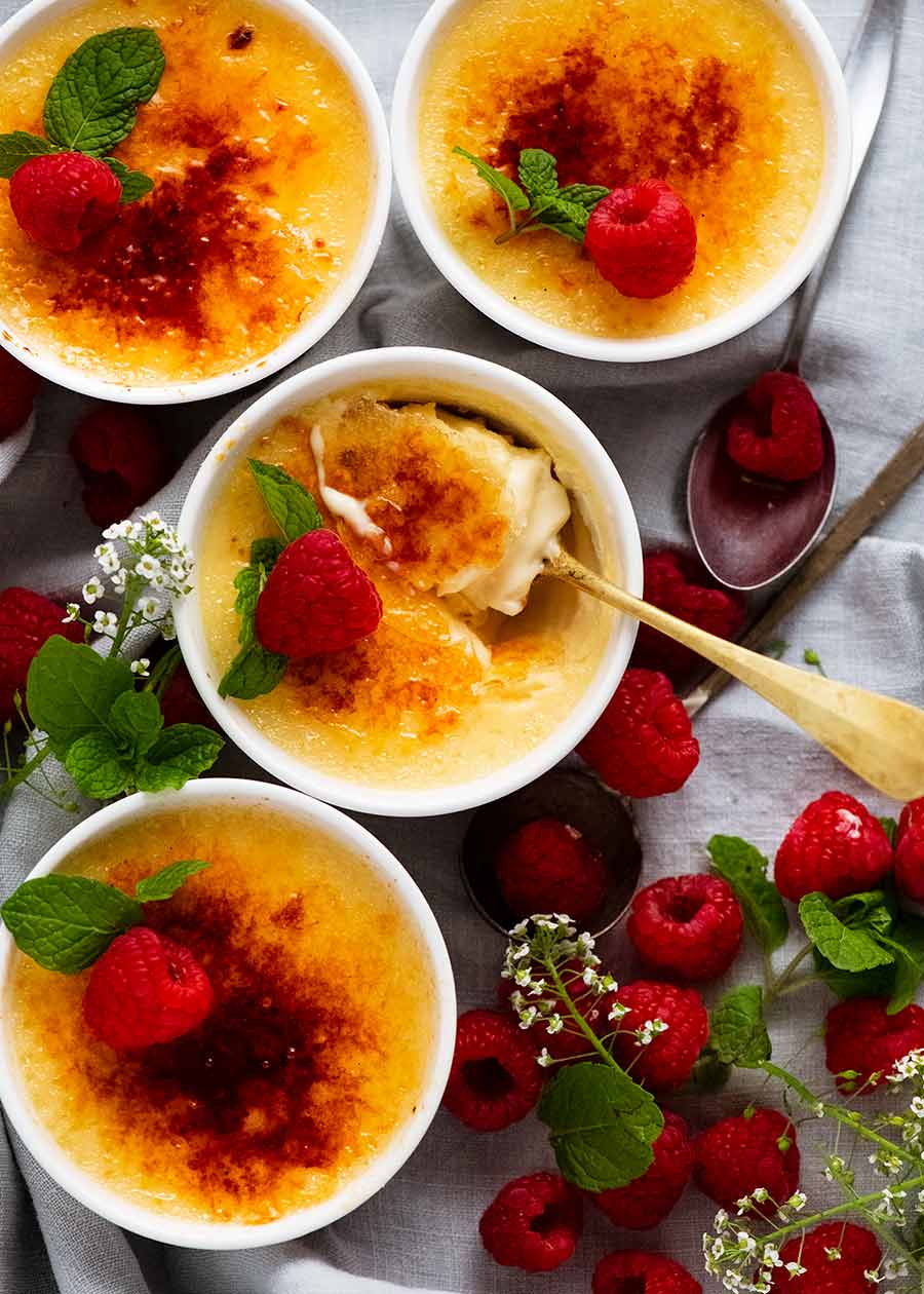 Overhead photo of Creme Brûlée decorated with raspberries and mint