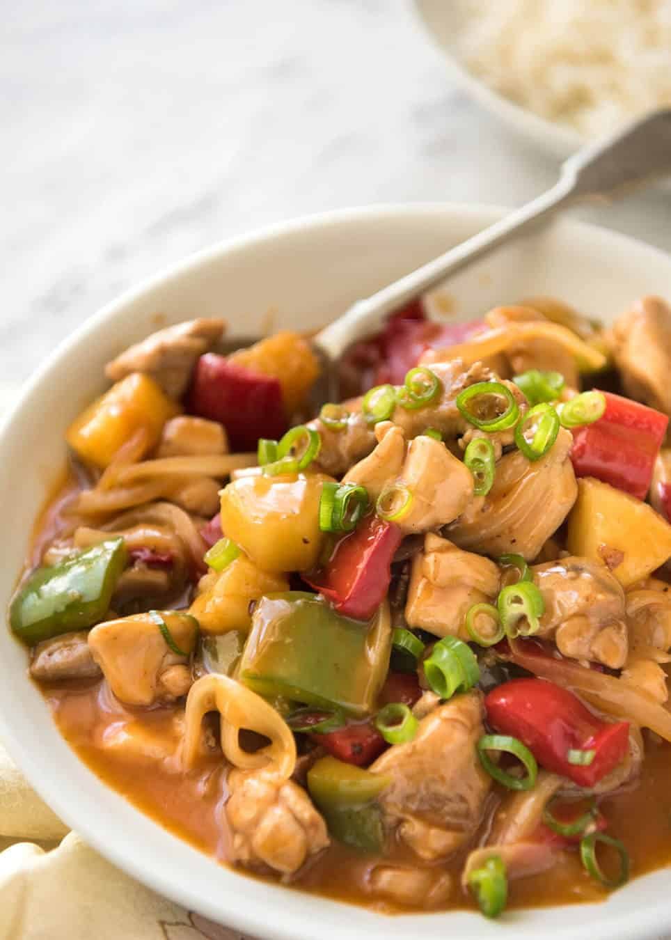 Golden sweet and sour chicken stir fry with colorful bell peppers and a glossy tangy sauce