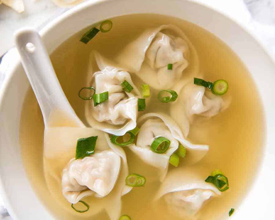 Overhead photo of Wonton Soup in a white bowl, ready to be eaten
