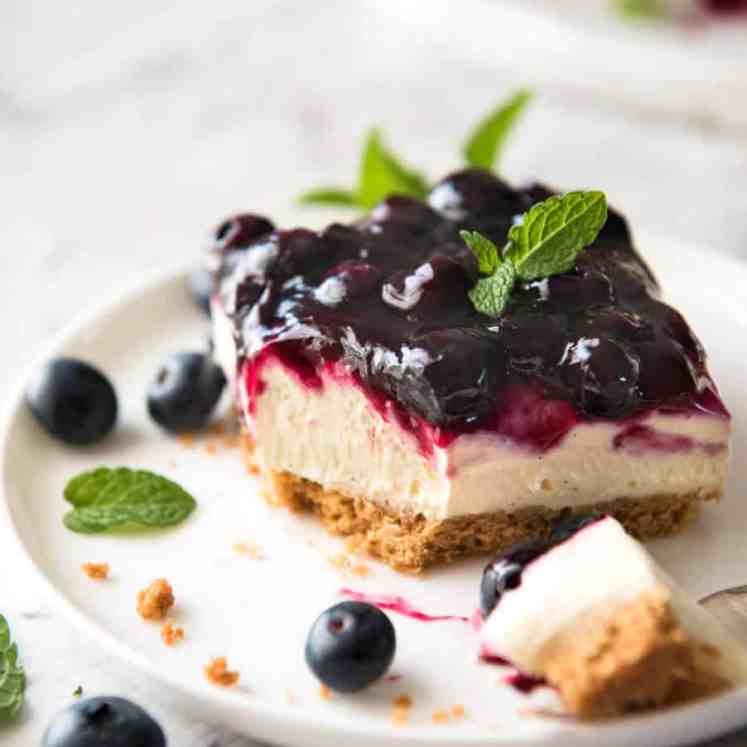 Easy and accelerated  No Bake Blueberry Cheesecake Bars - creamy cheesecake with a gorgeous caller  blueberry condiment  topping! recipetineats.com