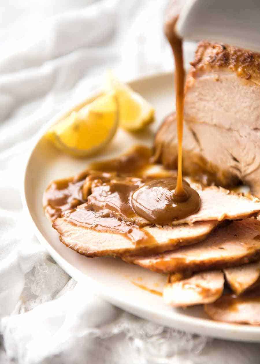 Gravy being poured over Slow Cooker Turkey Breast slices