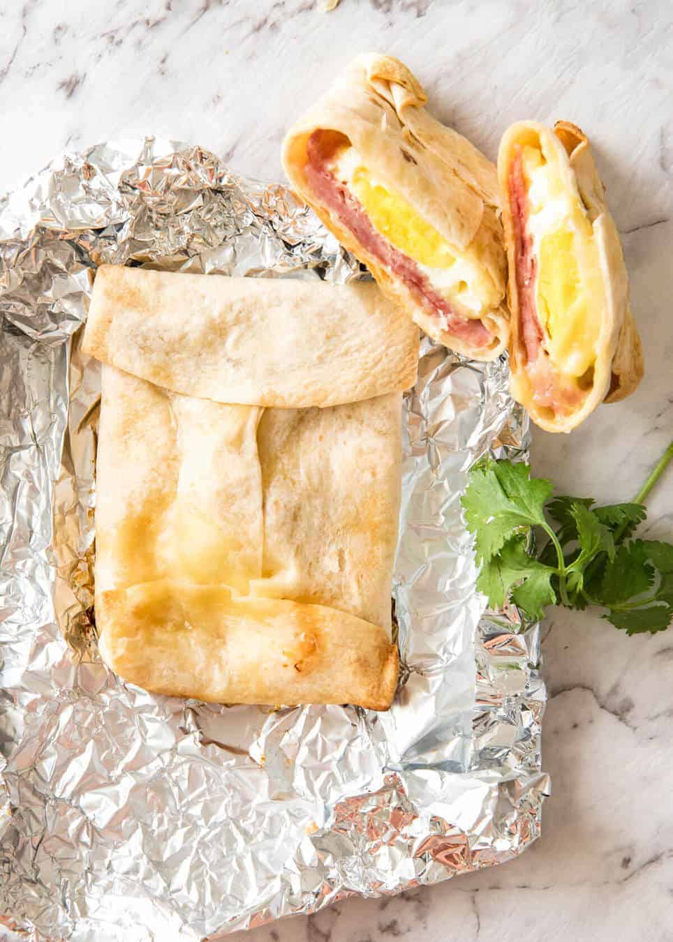 Hot ham, egg and cheese pockets made with tortillas wrapped in foil for baking.