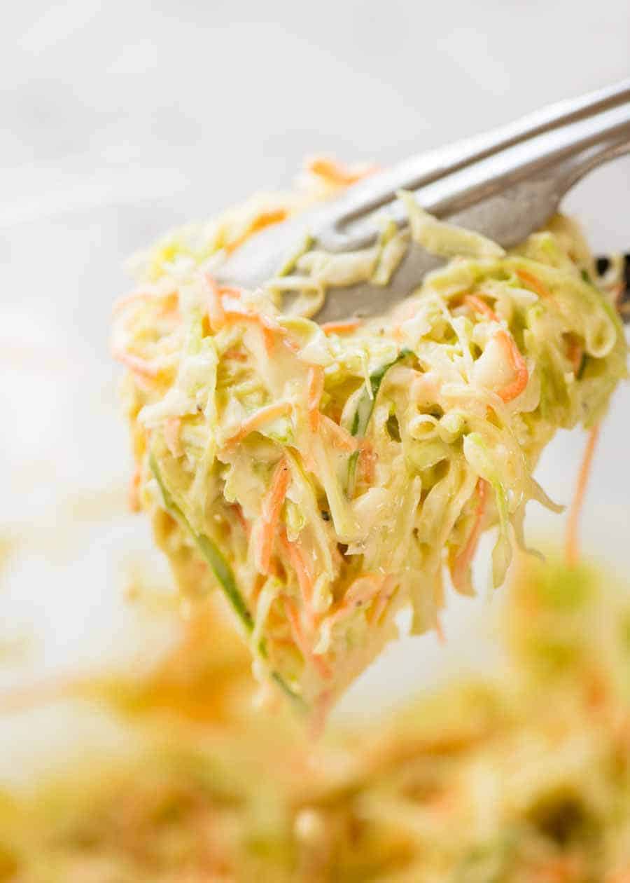 Coleslaw being served with tongs, showing how juicy the Coleslaw is.