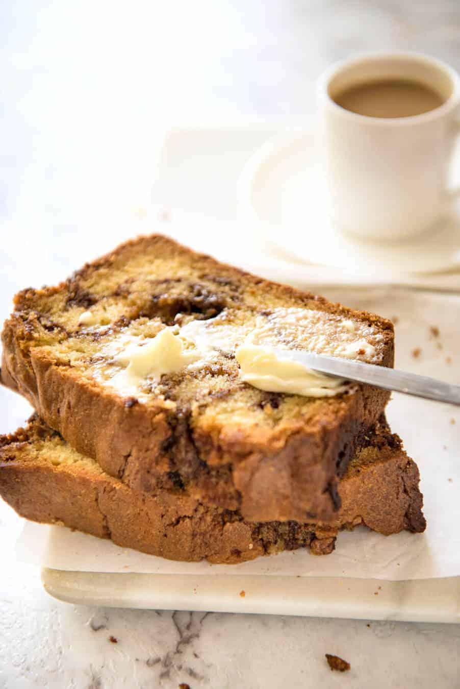 Two slices of Easy Cinnamon Bread with butter being spread on