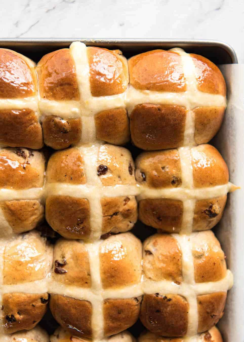 9 Homemade Hot Cross Buns photographed from overhead in a silver tray.