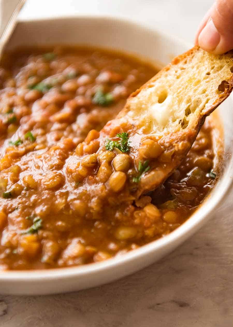 Close up of bread dipped in lentil soup